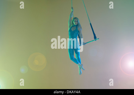 Trapeze artist holding trapeze Stock Photo