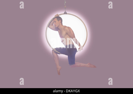 Male dancer balancing on hoop Stock Photo