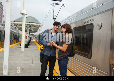 Couple listening to shared earphones at station, Los Angeles, California, USA Stock Photo