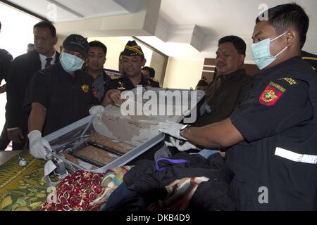 Yogyakarta, Indonesia. 4th Dec. 2013.  Indonesian Customs officers guard suspected of smuggling narcotics type of amphetamine, Esther Hulang, female Indian nationals during a press conference on December 04, 2013 at the office of Surveillance and Customs and Excise of Yogyakarta, Indonesia. Indonesian Customs of Adi Sutjipto International Airport in Yogyakarta, managed to thwart the smuggling of amphetamine (shabu-shabu) weighing 2,800 grams with a value of Rp 5.6 billion. Credit:  ZUMA Press, Inc./Alamy Live News Stock Photo