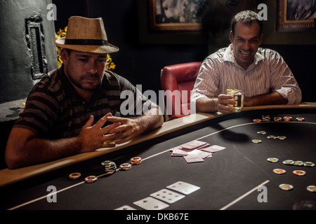 Mid adult men playing poker and drinking cocktails Stock Photo