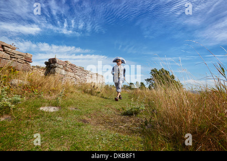 Boy wearing pirate costume running along grass, Eggergrund, Sweden Stock Photo