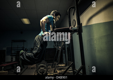 Weightlifter in dark gym, bench press Stock Photo