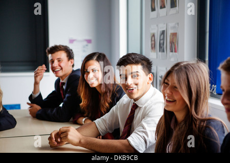 Teenage schoolchildren sitting at desks in classroom Stock Photo