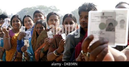 New Delhi, India . 04th Dec, 2013.  Residents show their voter identity cards before casting their votes at a polling booth in New Delhi, India, Dec. 4, 2013. The Indian capital on Wednesday went to assembly polls in which some 10 million residents are eligible to exercise their franchise to choose a new government for the state. Credit:  Xinhua/Alamy Live News Stock Photo