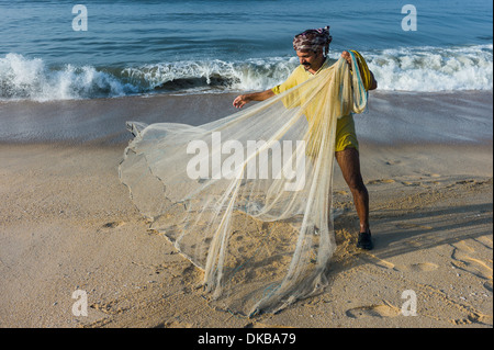 Fishermen with hand net prepares to cast into the sea along Thottada beach in the early morning, 10 km south of Kannur, Kerala. Stock Photo