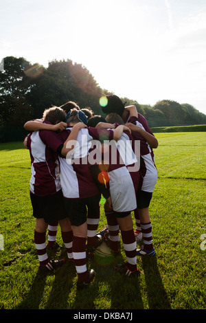 Teenage schoolboy rugby team in huddle Stock Photo