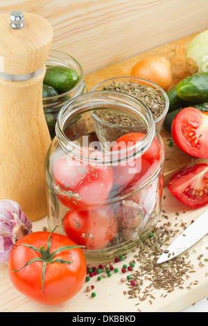 canned tomatoes and cucumbers in glass jar, homemade preserved vegetables Stock Photo