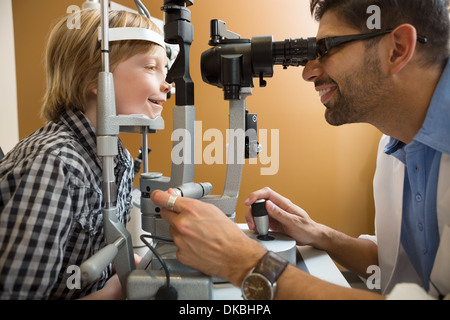 Optometrist Examining Boy's Eyes With Slit Lamp