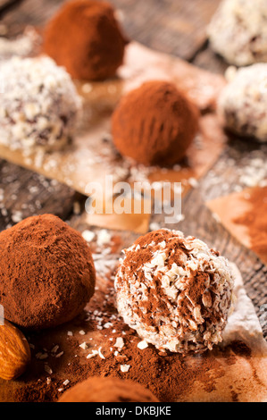 Sweet chocolate pralinas splashed on the table.Selective focus on the front praline Stock Photo