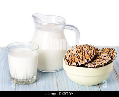 Composition milk in a jug, a glass and cookies on blue wooden background Stock Photo