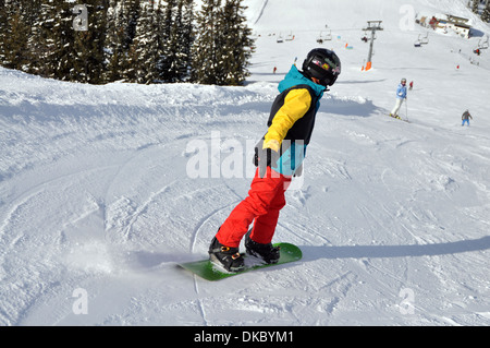 Twelve year old boy snowboarding, Zell am See, Austria. Stock Photo