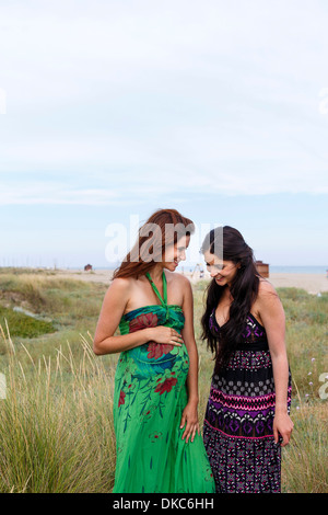 Pregnant woman and friend standing in field Stock Photo