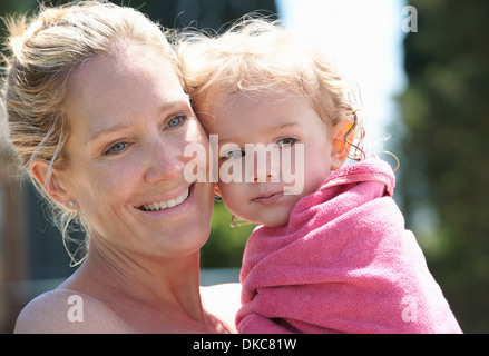 Mother holding toddler wrapped in towel Stock Photo