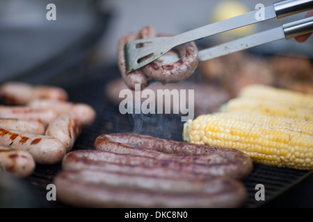 Barbecuing sausages and corn on the cob Stock Photo