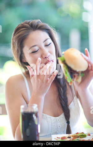 Young woman enjoying a burger Stock Photo