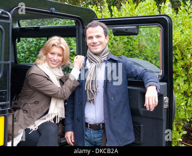 Portrait of mid adult couple next to landrover door Stock Photo