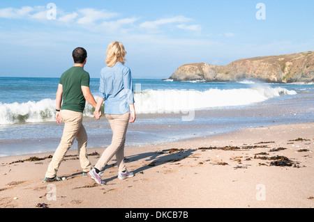 Mid adult couple walking on beach, Thurlestone, Devon, UK Stock Photo