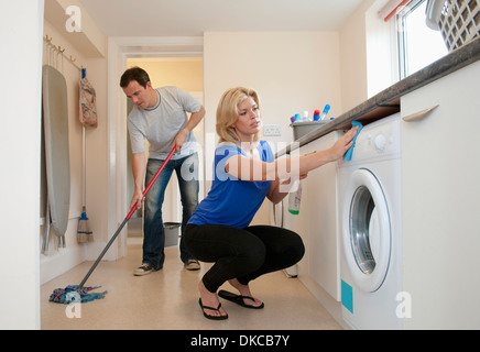 Mid adult couple cleaning kitchen in new home Stock Photo