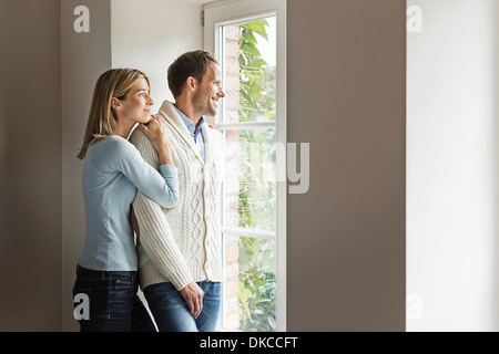Portrait of mid adult couple looking out of window Stock Photo
