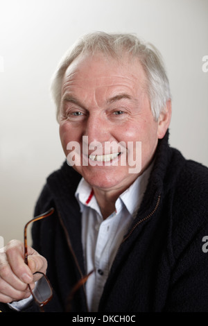 Close up portrait of senior man holding spectacles