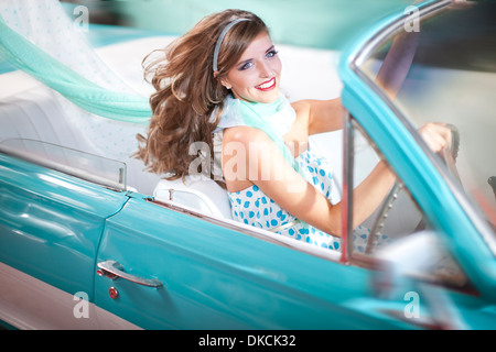 Woman with windblown hair driving vintage convertible Stock Photo