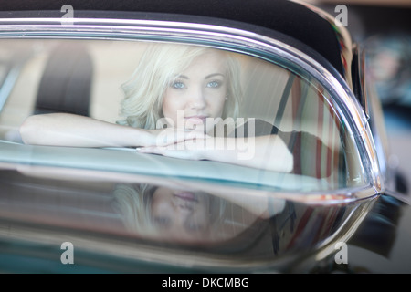 Woman looking out of rear car windscreen Stock Photo