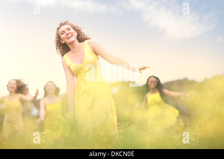 Girls in yellow dancing on meadow Stock Photo