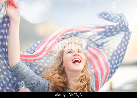 Woman waving with scarf of stars and stripes, Hout Bay, Cape Town, South Africa Stock Photo