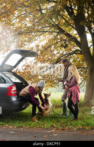 Family and dog preparing for walk from car boot, Norfolk, UK Stock Photo