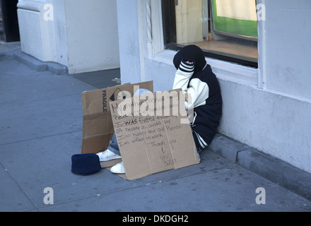 Young homeless man reaching out for help on the sidewalk near Union Square, NYC. Stock Photo