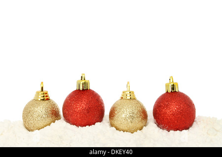 Red and gold Christmas baubles on snow with white copy space above Stock Photo