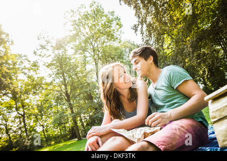 Young couple sitting together in park Stock Photo