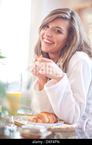 Portrait of young woman having breakfast in bed