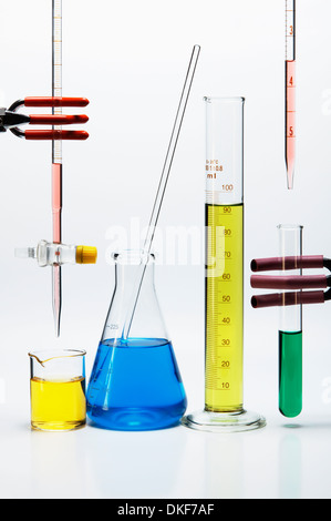 Chemical lab glassware: burette over beaker, Erlenmeyer flask with stirring rod, graduated cylinder, pipette over test tube Stock Photo