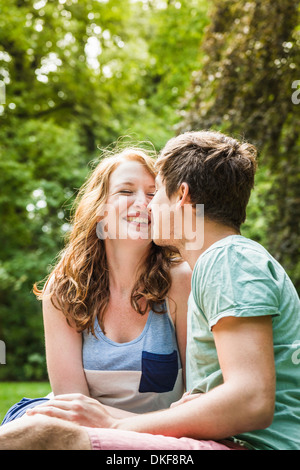 Young couple sitting in park Stock Photo
