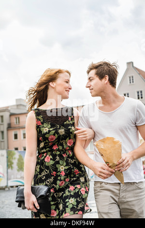 Young couple walking through town arm in arm Stock Photo