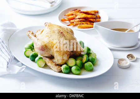 Still life of roast chicken with brussel sprouts and carrots Stock Photo