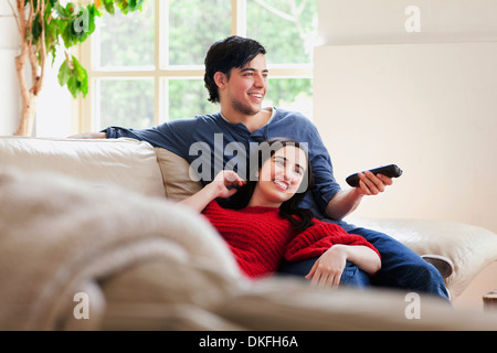 Young couple watching TV on living room sofa Stock Photo