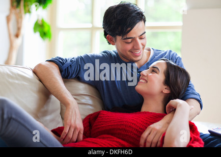 Young couple reclining on living room sofa Stock Photo