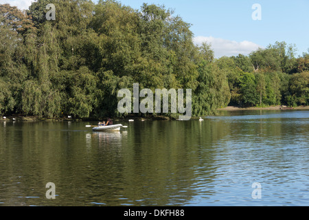 Woman with two children in a rowing boat on the boating lake at Heaton Park, Manchester. Stock Photo