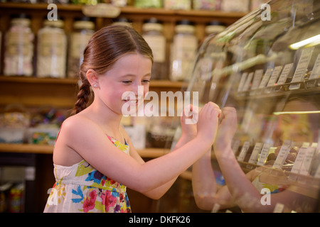 Girl looking at sweets in traditional sweet shop Stock Photo