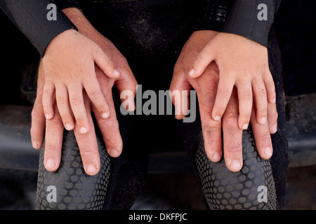 Boy's hands on top of father's hands Stock Photo