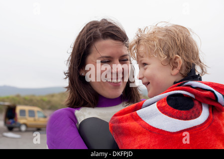 Portrait of mother holding son wrapped in a towel
