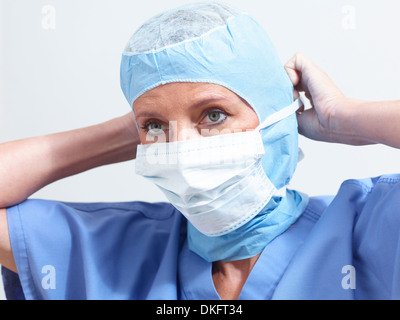 Surgeon putting on surgical mask Stock Photo