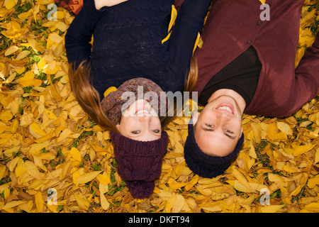Young couple lying in autumn leaves Stock Photo