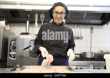 Woman working in restaurant kitchen Stock Photo