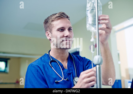 Doctor checking intravenous drip in hospital Stock Photo