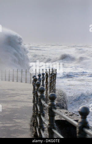 Blackpool, Lancashire, UK   5th December, 2013.  UK Weather gales.  Storm surge foaming seas and High Tide force closure of Blackpool promenade to vehicles and pedestrians as high winds and huge waves & flooding disrupts the town. 'Storm surges begin when a rising area of low pressure takes pressure off the surface of the sea, allowing it 'bulge' upwards,  as that pulls away, you get the very strong winds on the back edge of the low pressure and then that shoves that bulge of high sea levels down through the North Sea.'  Wind speeds were measured at 67mph. Stock Photo