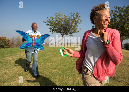 Senior couple running in park with kite Stock Photo